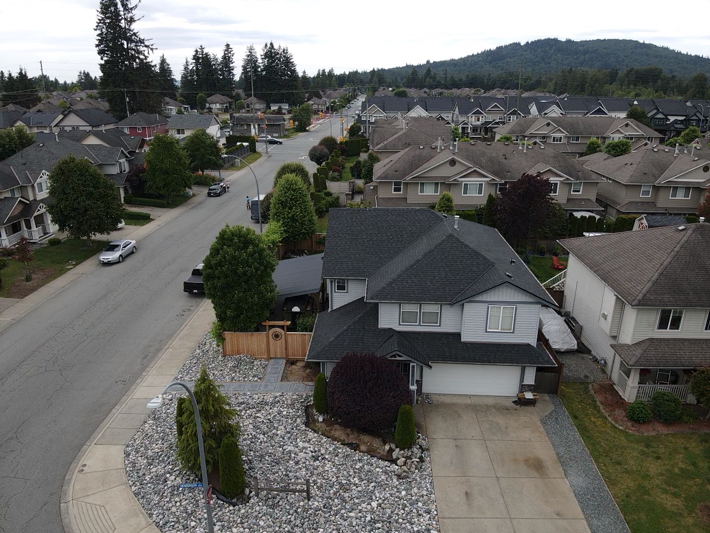 A professional roofer inspecting a flat roof in Metro Vancouver with drains and gutters visible, ensuring proper maintenance and water drainage.