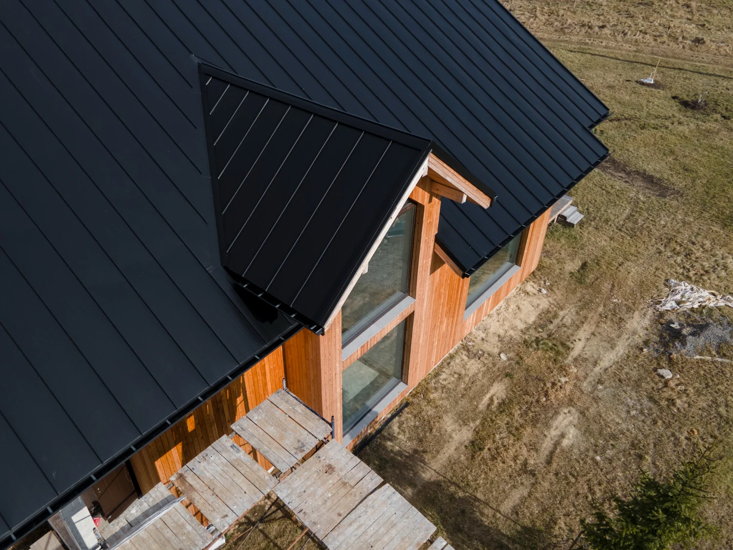 Home with a black metal roof and wooden stairs, built to withstand Vancouver’s coastal weather.